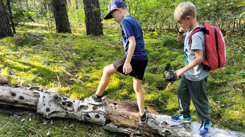 Nauczyciel prowadzący zajęcia outdoorowe z grupą dzieci w lesie